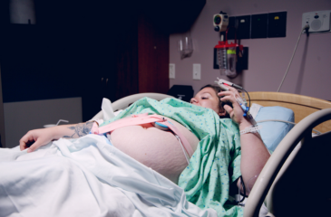 Pregnant woman in a hospital bed with stomach exposed