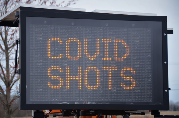 Road sign that reads "COVID SHOTS"