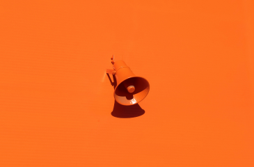 An orange megaphone sitting on an orange background