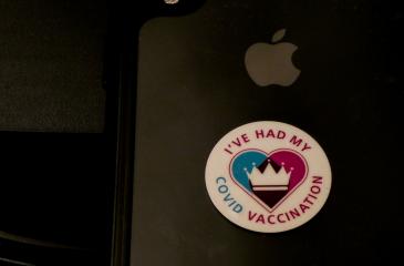 The back of a MacBook with a sticker on it reading "I've had my COVID Vaccination"