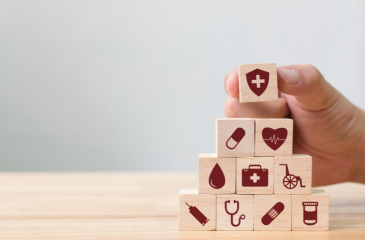 Wooden blocks with medical related icons stacked in a pyramid