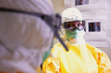 Two public health workers in full personal protective equipment