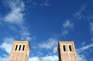Two old towers of a building shot against a blue sky