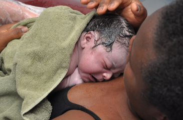 Black mother holding her infant directly after birth